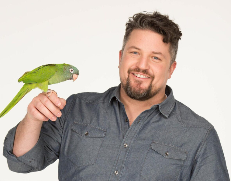 man holding parakeet